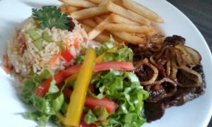 a plate of food with a salad and french fries at Hotel Leon in Barbalha