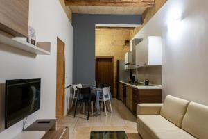 a living room and kitchen with a couch and a table at Great Siege Apartment in Senglea