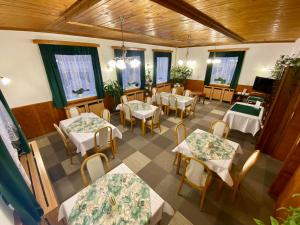 a dining room with tables and chairs and windows at Pension Helene s mini pivovarem in Kytlice