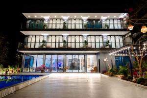 a large building with a swimming pool in front of it at Tam Coc Wonderland Lodge in Ninh Binh