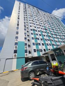 una motocicleta estacionada frente a un edificio alto en Lloyds Barato 2BR Condo Unit 6paxMax, en Mandaue
