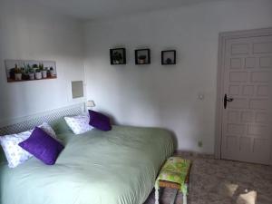 una camera da letto con un grande letto con cuscini viola di COTOBRO - La Palmera Apt ad Almuñécar