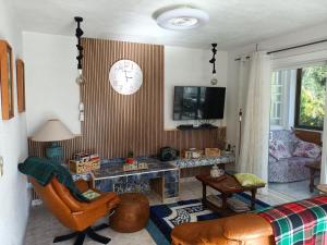 un soggiorno con un divano e un orologio a parete di COTOBRO - La Palmera Apt ad Almuñécar Altre 15 foto