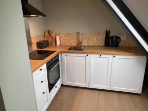 een keuken met witte kasten en een houten aanrechtblad bij Ferienwohnung Wolkenplatz in Winterberg