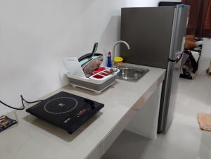 a kitchen counter with a sink and a refrigerator at BHS SERVICED APARTMENTS 2 BR in Carcar City in Guinauayan