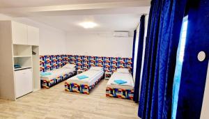ein Krankenzimmer mit zwei Betten und blauen Vorhängen in der Unterkunft Ridos in Constanţa