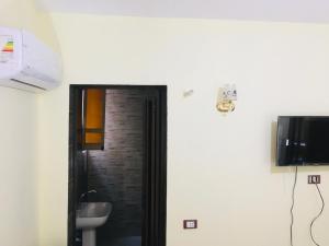 a door to a bathroom with a sink and a television at Cairo Lodge Hostel in Cairo