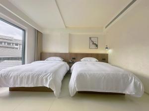 Giường trong phòng chung tại Zhangjiajie JoyMaple Hotel