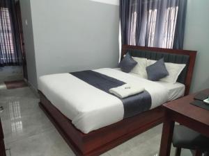 a bed with white sheets and blue pillows in a room at MTP residency in Payyannūr