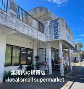 a large building with a small supermarket sign on it at 宮古島の自然豊かで静かなエリアroom1オリジナルインテリア小物が溢れる空間 in Miyako Island