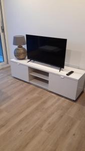 a flat screen tv sitting on a white entertainment center at L'ARMONIA entre la Farella i Cau del LLOP in Llança