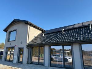 a building with a car parked in a parking lot at Domki pod Kurzą Górą in Kurzętnik