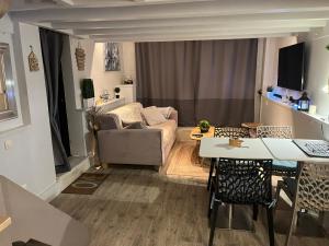 DampmartにあるGuest House proche Disneyland Paris Réouverture Piscine fin avrilのソファとテーブルのあるリビングルーム