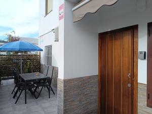 a patio with a table and a blue umbrella at Apartamento Fortes in San José