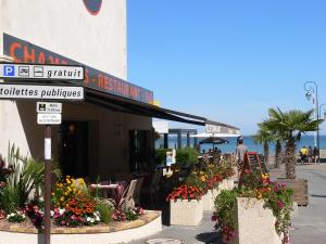 a restaurant with flowers in front of a building at La Maison Du 6 in Arromanches-les-Bains