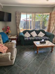 a living room with a couch and a table at Susan's Holiday House in Hamilton