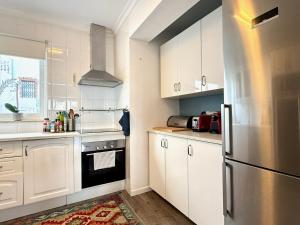 a kitchen with white cabinets and a stainless steel refrigerator at Villa Ibiza by Solrentspain - La Cala de Mijas in Mijas Costa