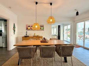 a dining room with a wooden table and chairs at Villa Ibiza by Solrentspain - La Cala de Mijas in Mijas Costa