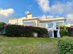 a white house with flowers in front of it at Villa Ibiza by Solrentspain - La Cala de Mijas in Mijas Costa