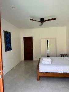 a bedroom with a bed and a ceiling fan at Villa The Palm Sip Song in Koh Phangan