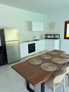 a kitchen with a wooden table with chairs and a refrigerator at Villa The Palm Sip Song in Koh Phangan