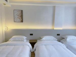 Giường trong phòng chung tại Zhangjiajie JoyMaple Hotel