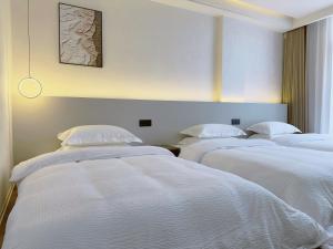 Giường trong phòng chung tại Zhangjiajie JoyMaple Hotel
