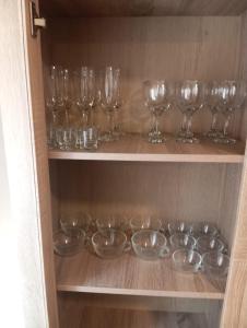 a row of wine glasses and bowls on a shelf at PLAZA AYUNTAMIENTO 3 HABITACIONES PONDoS in Linares