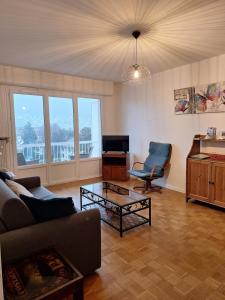 a living room with a couch and a table at Chez Isabelle et Florent - Logis Familial du Lac in Annecy