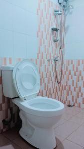 a white toilet in a bathroom with a shower at WJV Inn Bohol in Tagbilaran City