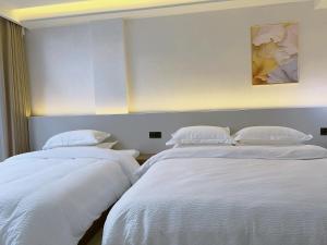Giường trong phòng chung tại Zhangjiajie JoyMaple Hotel