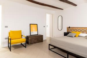 una camera da letto con un letto e una sedia gialla di Tra i vicoli di Napoli, La Olivella design e amore a Napoli
