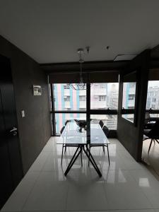 een tafel en stoelen in een kamer met een groot raam bij Modern Studio at NAIA Terminal 3 in Manilla +9 foto's
