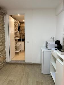 a kitchen with white walls and a counter with a microwave at Forno House - Quarto peregrinos Caminho Santiago in Âncora