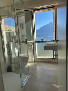 a bathroom with a shower and a sink and a window at Residenza Arazzo in Minusio +10 photos