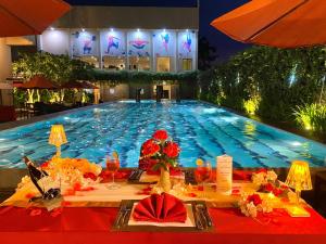 a large swimming pool with a table in front of it at Grand Zuri Dumai in Dumai