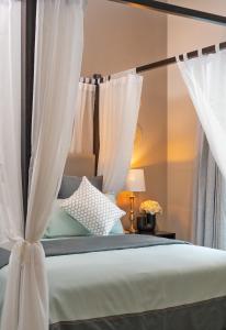 a bedroom with a canopy bed with white curtains at Lasantha in Dickwella