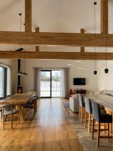 an open living room with a wooden table and chairs at Zielono Mi! Dom przy Puszczy Kampinoskiej in Grądy