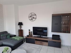ein Wohnzimmer mit Couch und Flachbildfernseher in der Unterkunft Ferienwohnug mit Balkon und Carport in Dülmen