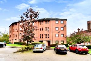 tre auto parcheggiate in un parcheggio di fronte a un edificio di Chic & Cozy 2-Bed Flat in Glasgow - Free Parking a Glasgow