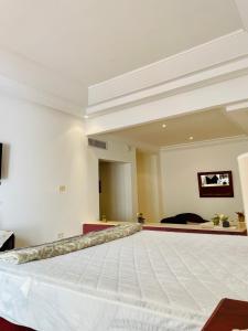 a large white room with a large bed in it at Agréable villa a Ennacer in Ariana
