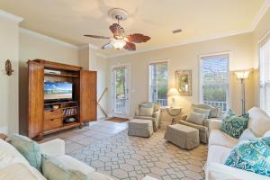 Una sala de estar con sofás y un televisor de pantalla plana. en Mandevilla, en Gulf Shores