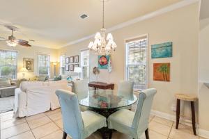 Un comedor con una mesa de cristal y sillas. en Mandevilla, en Gulf Shores