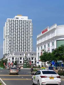 a white car driving down a city street with buildings at APEC MANDALA Tuy Hòa in Liên Trì (4)