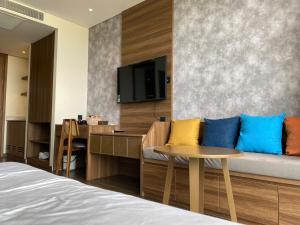 a room with a couch and a table and a tv at APEC MANDALA Tuy Hòa in Liên Trì (4)