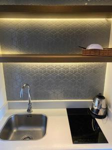 a kitchen with a sink and a tiled wall at APEC MANDALA Tuy Hòa in Liên Trì (4) +9 photos