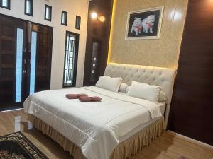 a bedroom with a bed with two towels on it at Alya Homestay Meulaboh in Meulaboh