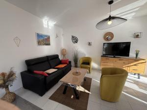 a living room with a black couch and a tv at AwayDays - Casa con Piscina in Empuriabrava