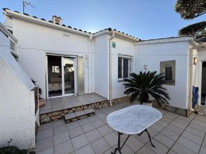 a patio with a table and a house at AwayDays - Casa con Piscina in Empuriabrava