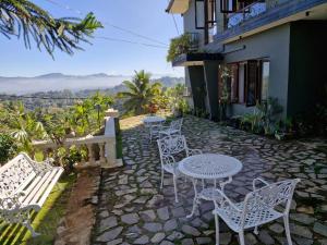 a group of white tables and chairs on a patio at No63 Amy's in Kandy